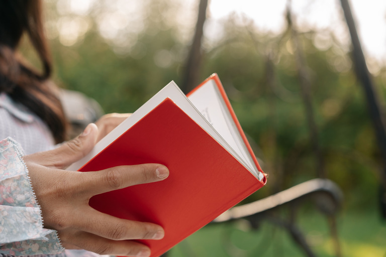 Рука держит насыщенно-красную книгу сначала у окна, затем под лампой, цвет заметно меняется