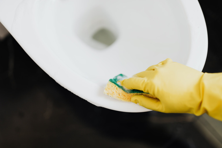 Стена цвета тёплой глины, которую моют губкой с моющим раствором, чистая полоса контрастирует с запылённой